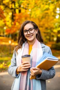 outdoor-autumn-portrait-happy-smiling-teenage-girl-with-copybooks